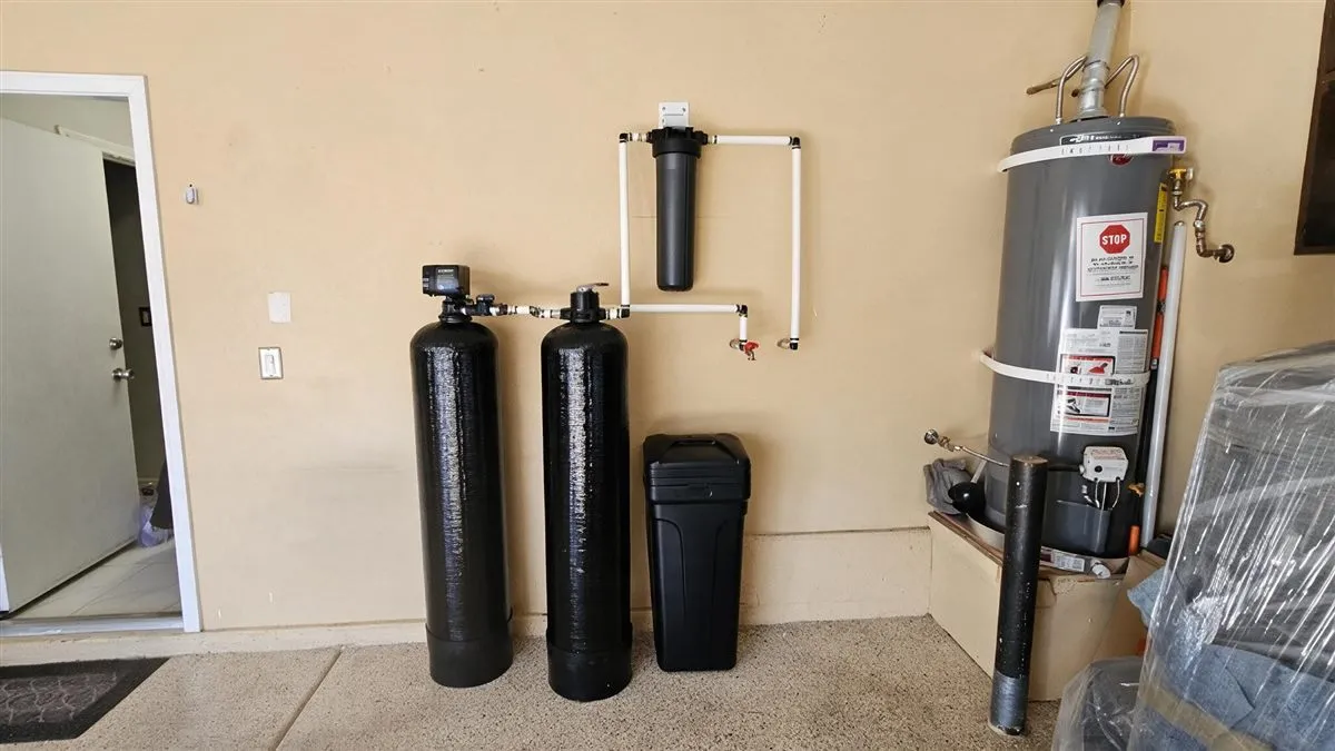 A larger two-tank softener and filtration install beside the water heater in a Las Vegas garage