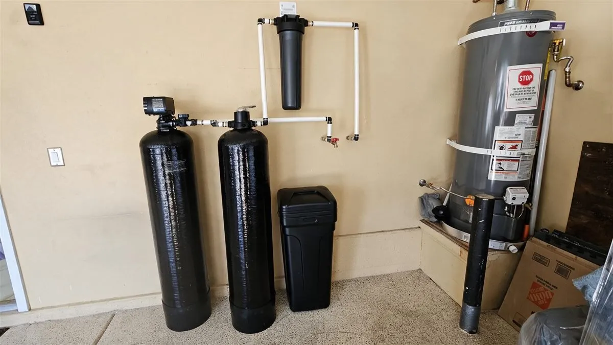 A whole-home water softener installed beside a residential water heater in Las Vegas