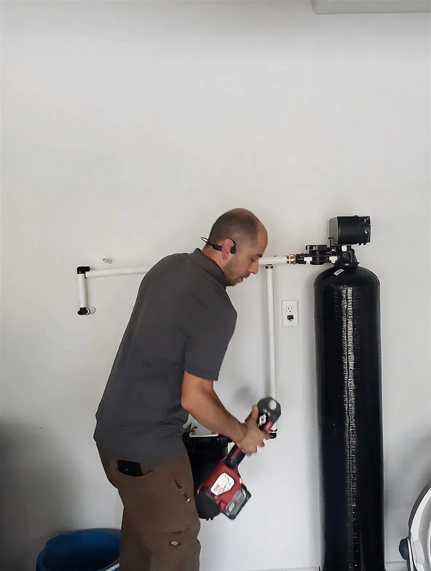 Our technician working on a whole-home water softener install in a Las Vegas garage