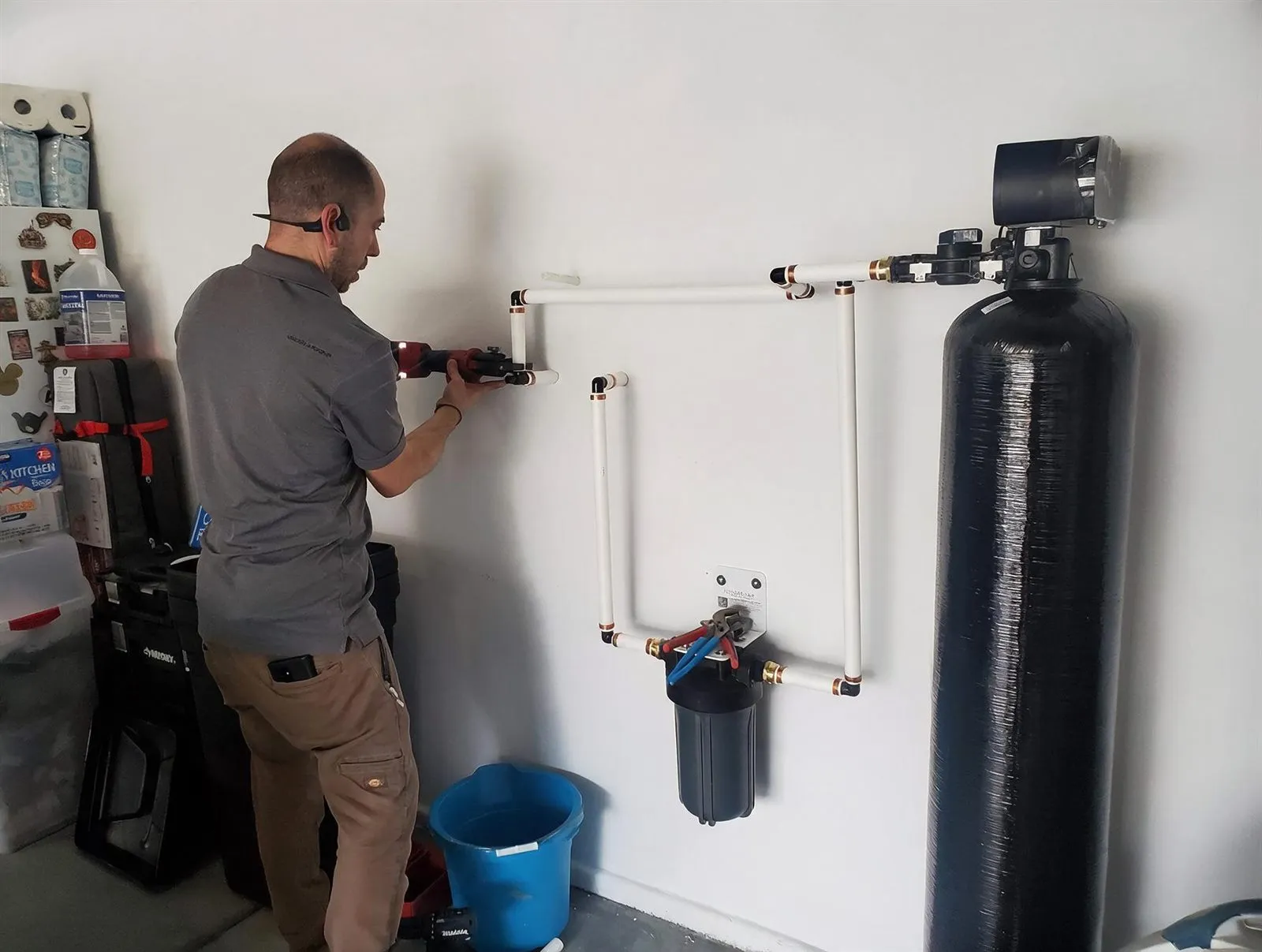 Our technician plumbing a softener loop and filtration system in a Henderson garage